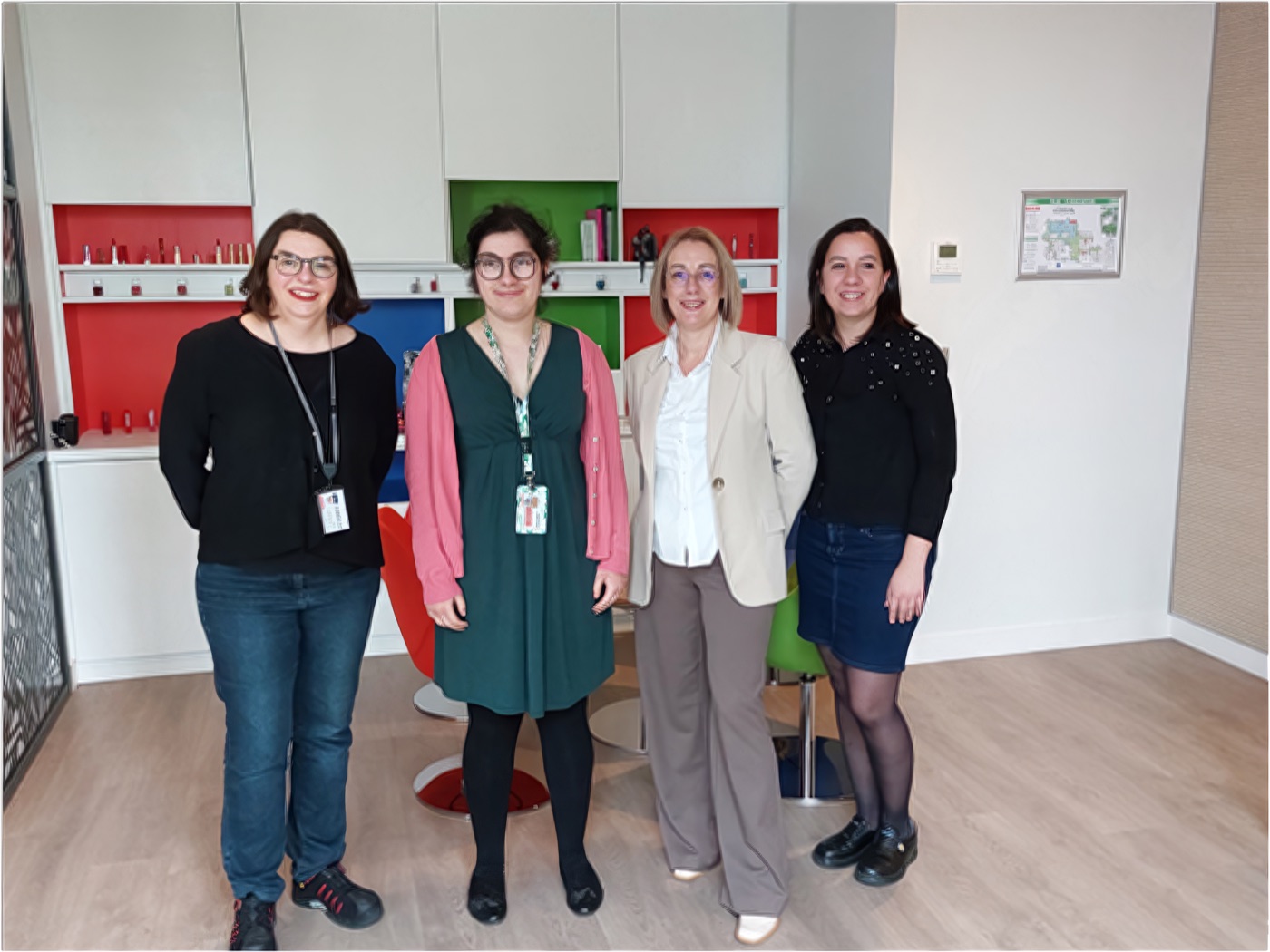 Quatre personnes posent ensemble dans un espace de travail L’Oréal.
