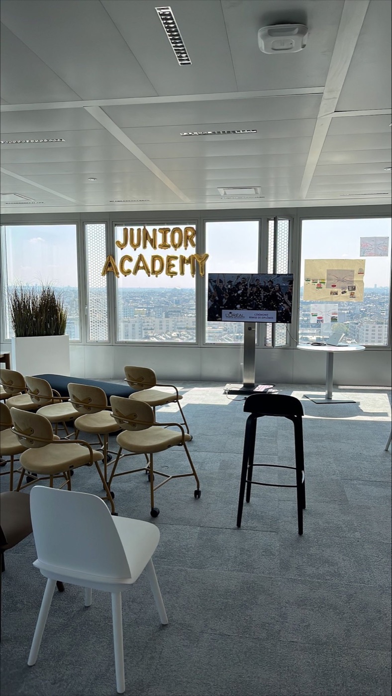 Salle de la Junior Academy avec des chaises, un écran et des supports d’atelier.
