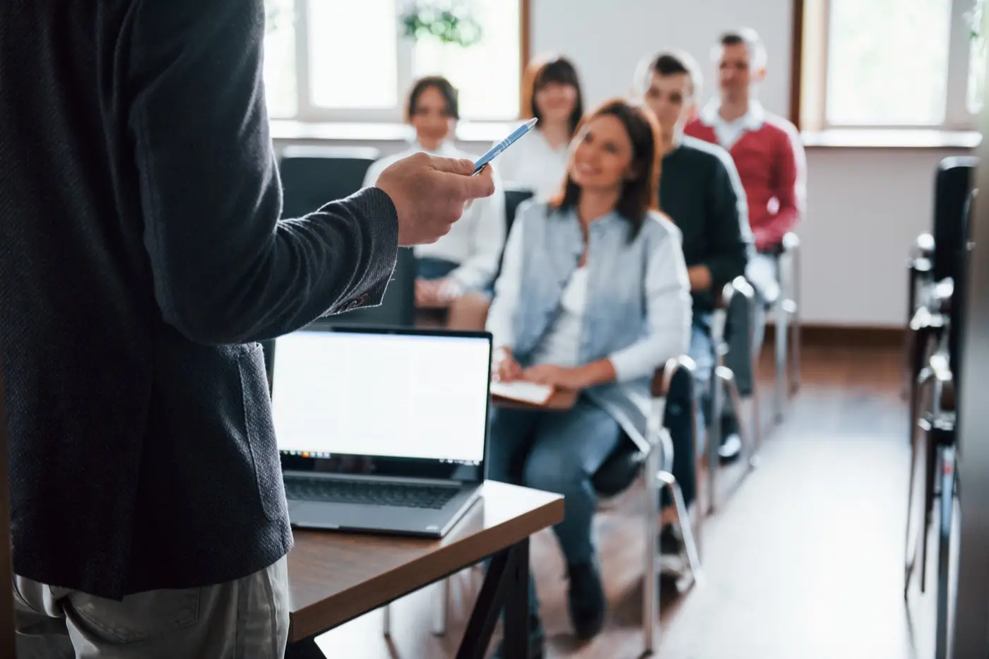 Un intervenant fait face à un groupe de participants assis, dans une salle de formation.